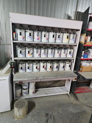 de nombreux pots de peinture posés sur une étagère dans un garage