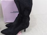 the black boots are next to a pink box on the floor