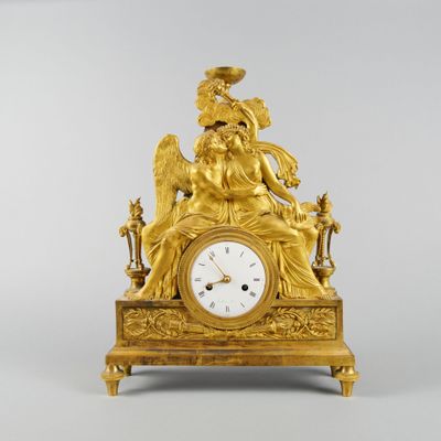 une image représentant une horloge en or surmontée d'un ange