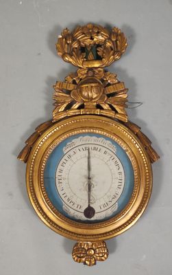 une horloge en or accrochée au mur, sur laquelle se trouve un cadran