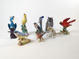 cinq figurines d'oiseaux posées sur une surface blanche
