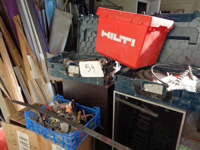 beaucoup de bric-à-brac dans un garage où se trouve une boîte rouge