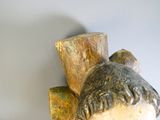 une sculpture en bois représentant un homme coiffé d'un chapeau