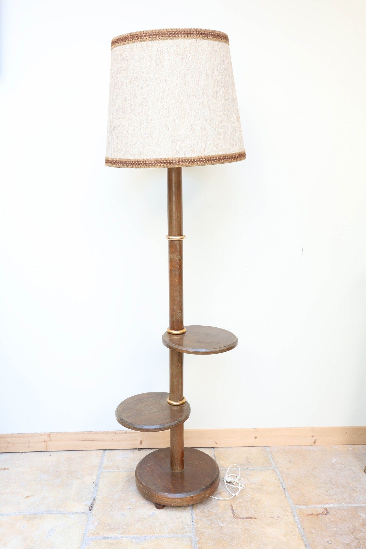 Un lampadaire en bois à deux petites étagères circulaire en …