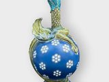 un vase bleu surmonté d'un oiseau
