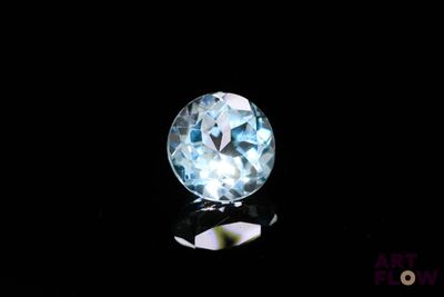 a close up of a blue topaz diamond on a black surface