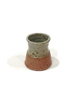 a small cup that is sitting on a white surface