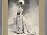 une vieille photo d'une femme en robe et avec un chapeau