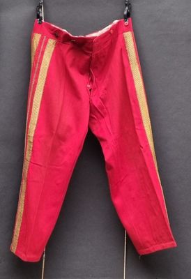 un pantalon rouge accroché à un mur noir
