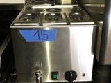 un plan de travail en acier inoxydable sur lequel sont posés des casseroles et des poêles