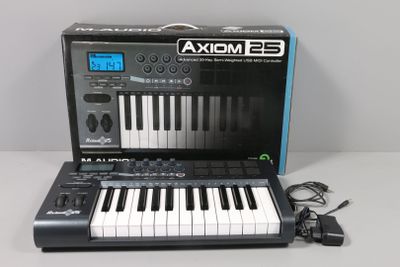 an image of a black and white electronic keyboard with a charger
