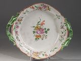 une assiette décorée de fleurs, posée sur un socle
