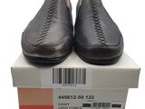 une paire de chaussures pour homme posée sur une boîte, avec un code-barres sur le côté