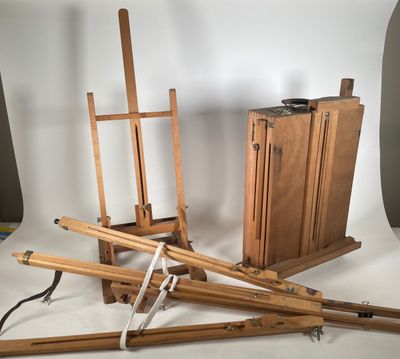 une photo représentant un ensemble de chevalets en bois et une boîte de peinture