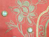 a close up of a red jacket with gold embroidery on it