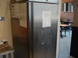 a refrigerator in the corner of a kitchen with a table and chairs