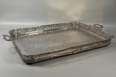 an ornate silver tray with handles and handles on a table