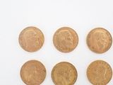 six different types of gold coins are shown on a white surface