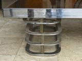 a metal table with a glass top on a tiled floor