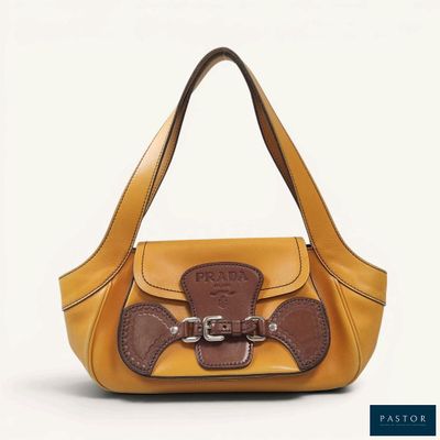 the small yellow purse is sitting on a white surface