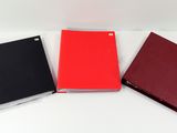 three red and black notebooks sitting on top of a white table