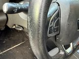 a steering wheel and dashboard of a car with a clock on it