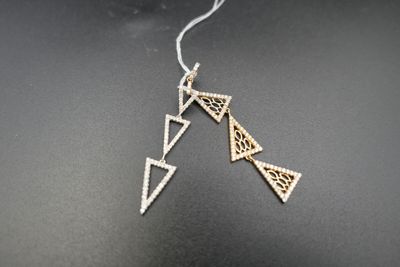 a close up of a pair of earrings on a black surface