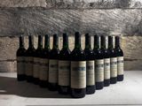 Plusieurs bouteilles de vin sont alignées contre un mur de pierre