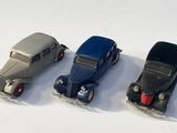 quatre petites voitures sont alignées sur une surface blanche