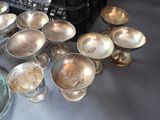 a lot of silver dishes and cups on a table