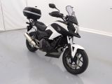 une moto noire et blanche garée dans une pièce blanche
