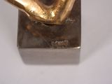 a gold sculpture of a hand holding a ball