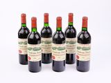 six bouteilles de vin rouge alignées sur une surface blanche