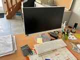 un bureau sur lequel se trouvent un ordinateur, un clavier, une calculatrice et d'autres fournitures de bureau