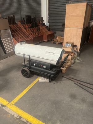 a large white proprigerator sitting in a warehouse