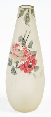 un vase blanc orné de fleurs rouges, posé sur une surface blanche