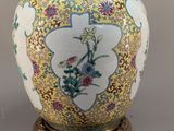 a vase with a bird on it sitting on a stand