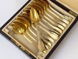 six cuillères dans une boîte posée sur une table blanche