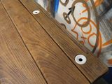 a wooden table with holes in it and graffiti on the wall