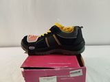 a close up of a pair of black and yellow shoes on a pink box