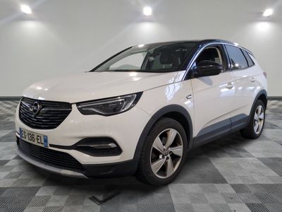 un SUV Opel blanc garé dans un garage au sol en damier