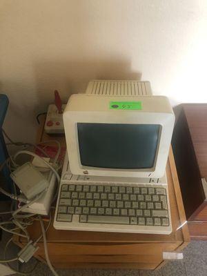 un petit ordinateur posé sur un bureau en bois