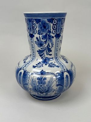 a blue and white vase sitting on a white surface