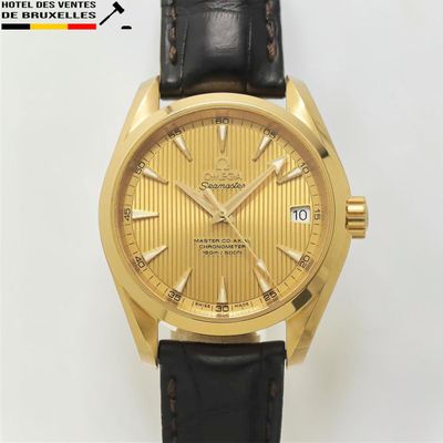 une image montrant un gros plan d'une montre en or avec un bracelet noir