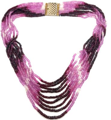 un gros plan sur un collier à plusieurs rangs muni d'un fermoir en or
