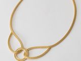 an image of a gold necklace on a white surface