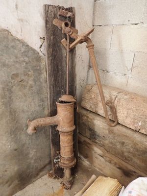 une pompe à eau rouillée dans un coin de la pièce