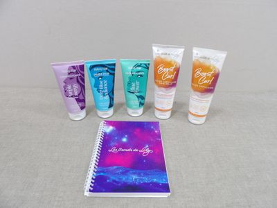 cinq tubes de crème pour les mains et un cahier posés sur une table