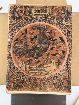 un vieux livre sur lequel figure l'image d'un coq