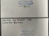 two business cards on a table with a pen and ink